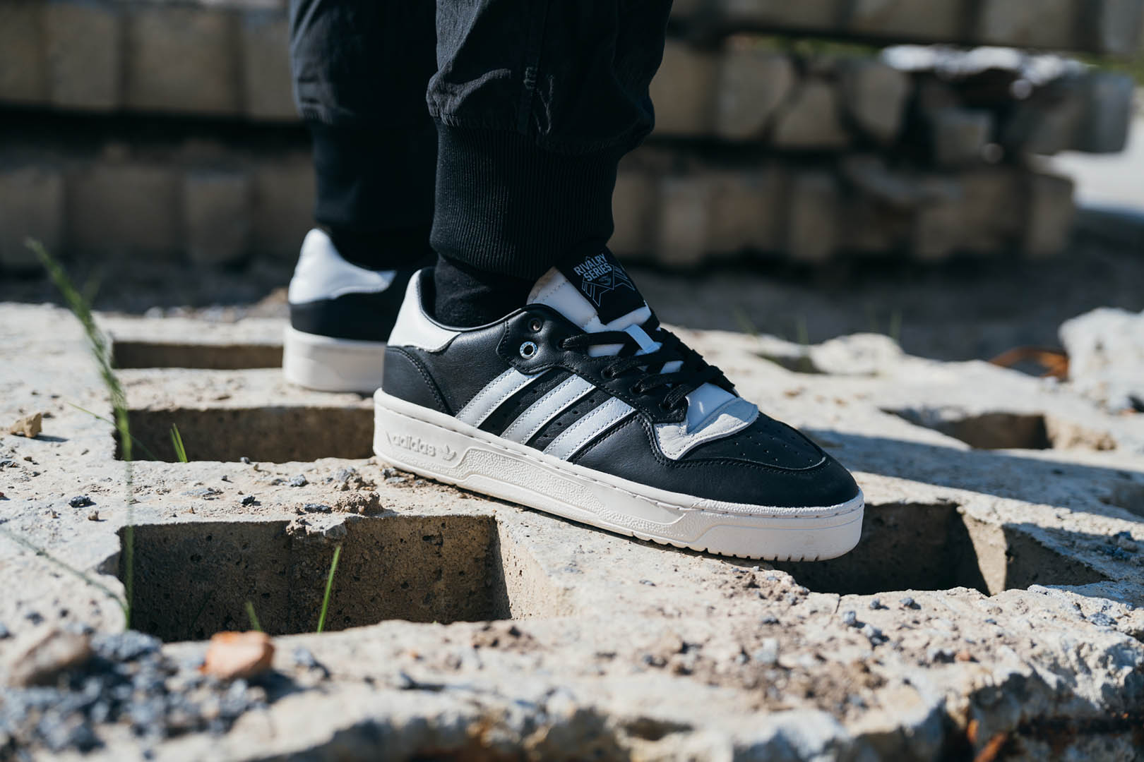ADIDAS ORIGINALS RIVALRY LOW CONSORTIUM TRAINERS - CORE BLACK / SILVER METALLIC / GREY ONE